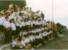 primary students posing for a group photo on the shore of lake geneva