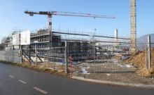 scaffolding surrounding the praz-dagoud campus under construction behind a fence