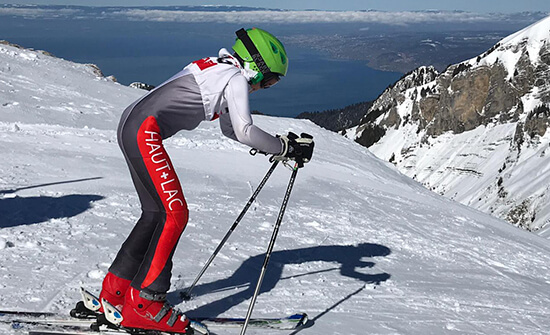 student in a ski suit preparing to start a slalom run while skiing