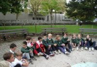 old photo of primary students sitting by a water fountain in vevey